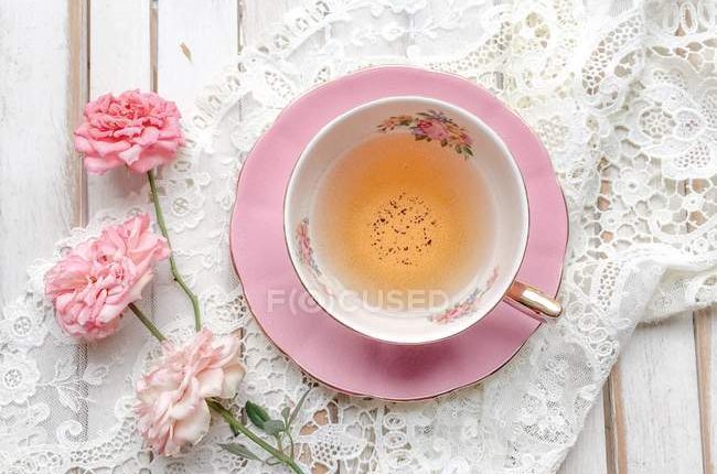 focused_193307328-stock-photo-cup-tea-roses-lace-top