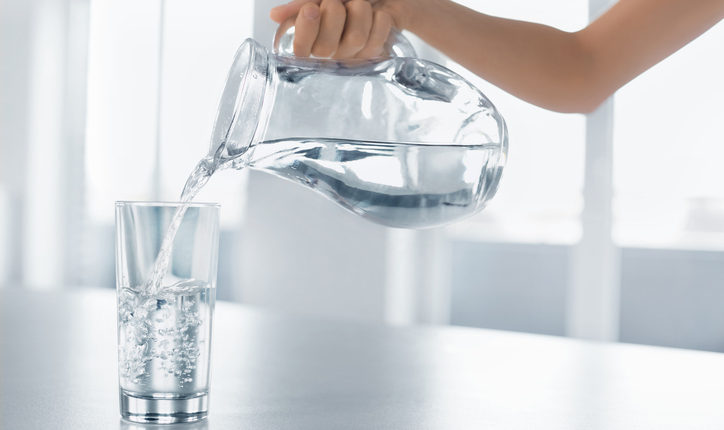 Drink Water. Woman’s Hand Pouring Water From Pitcher Into Glass